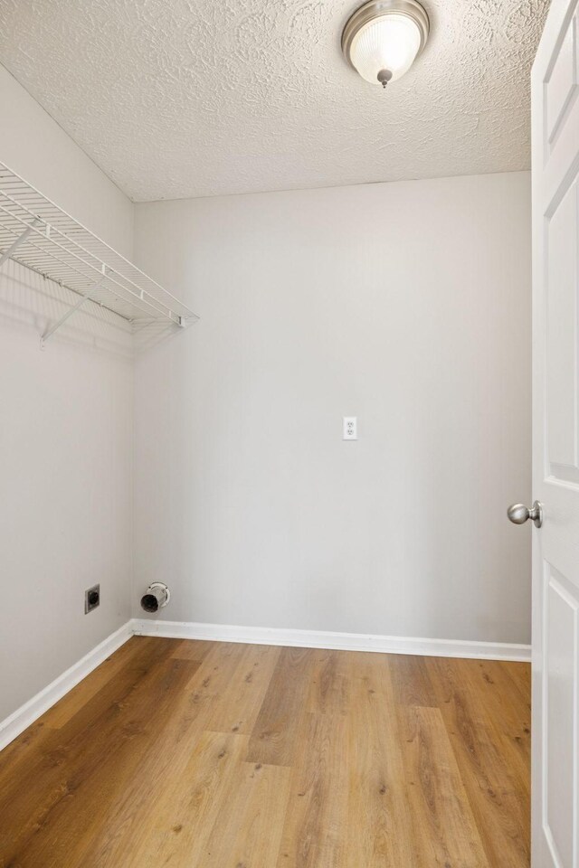 1882 Portway Rd, Spring Hill, TN 37174 - laundry room with hookup for an electric dryer, light wood-type flooring, and a textured ceiling
