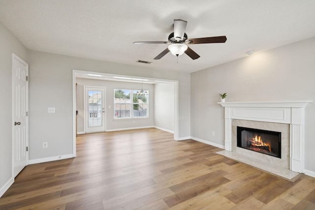 1882 Portway Rd, Spring Hill, TN 37174 - unfurnished living room featuring ceiling fan, wood finished floors, a premium fireplace, and a chandelier