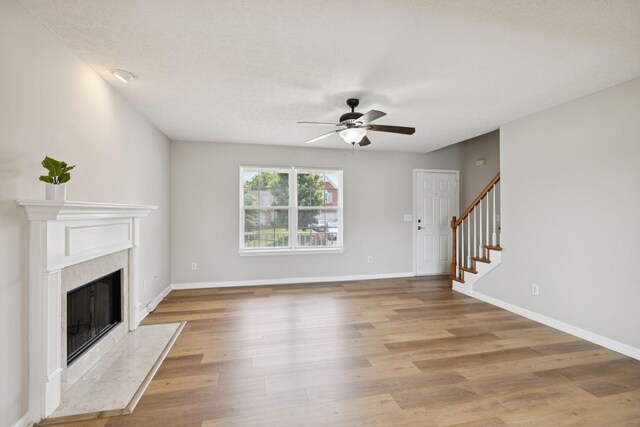 1882 Portway Rd, Spring Hill, TN 37174 - unfurnished living room with ceiling fan, light wood finished floors, stairs, and a fireplace
