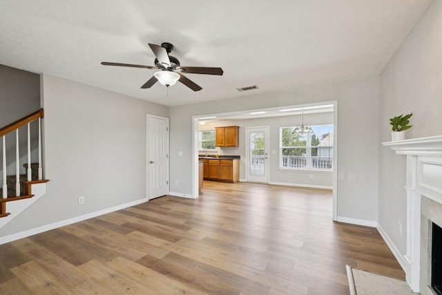1882 Portway Rd, Spring Hill, TN 37174 - unfurnished living room with a ceiling fan, a premium fireplace, light wood-type flooring, and stairs