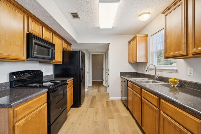 1882 Portway Rd, Spring Hill, TN 37174 - kitchen with black appliances, light wood-style floors, a textured ceiling, dark stone counters, and brown cabinetry