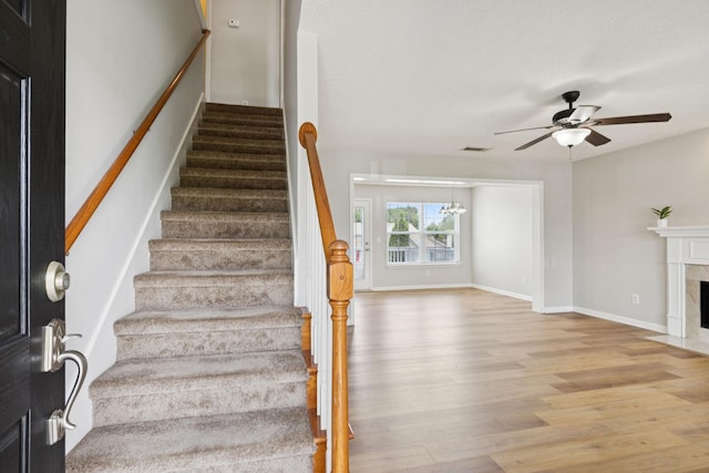 1882 Portway Rd, Spring Hill, TN 37174 - stairs with wood finished floors, a ceiling fan, a high end fireplace, and a chandelier