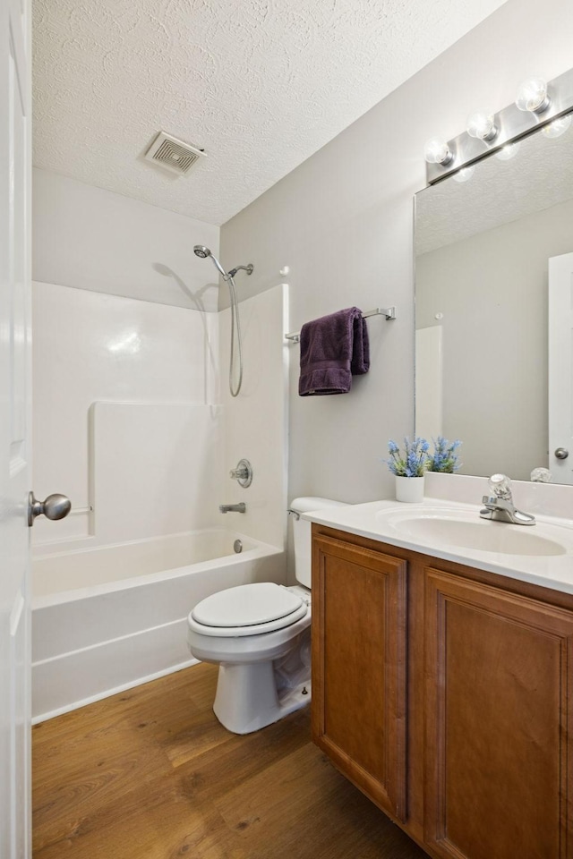 1882 Portway Rd, Spring Hill, TN 37174 - bathroom featuring wood finished floors, vanity, shower / bathtub combination, and a textured ceiling