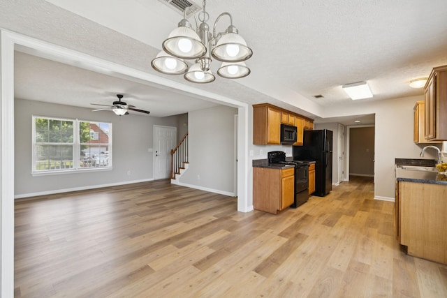 1882 Portway Rd, Spring Hill, TN 37174 - kitchen featuring black appliances, a textured ceiling, dark countertops, light wood-style flooring, and brown cabinetry