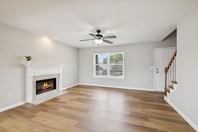 1882 Portway Rd, Spring Hill, TN 37174 - unfurnished living room with ceiling fan, a premium fireplace, light wood-style floors, and stairway