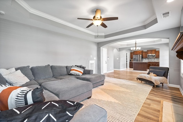 1613 Kestrel Dr, Clarksville, TN 37040 - living area with a raised ceiling, arched walkways, ceiling fan, light wood-style floors, and crown molding