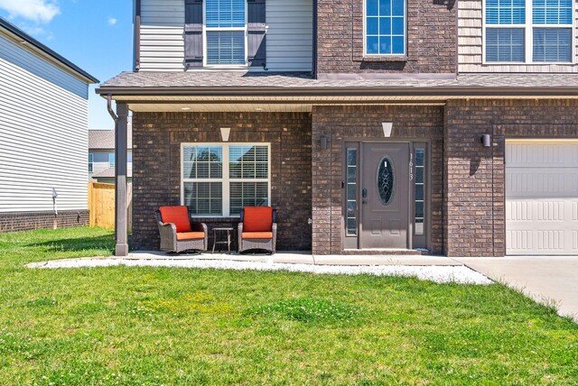 1613 Kestrel Dr, Clarksville, TN 37040 - view of exterior entry featuring a lawn, brick siding, a garage, a porch, and a shingled roof