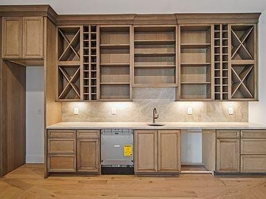 6128 Lookaway Cir, Franklin, TN 37067 - indoor bar featuring stainless steel dishwasher, backsplash, and light wood-type flooring