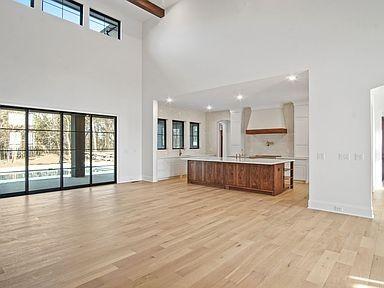 6128 Lookaway Cir, Franklin, TN 37067 - kitchen featuring a towering ceiling, open floor plan, custom range hood, light countertops, and light wood-style flooring
