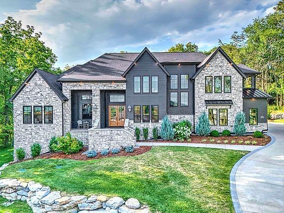 6128 Lookaway Cir, Franklin, TN 37067 - view of front of house with stone siding, a front yard, and a standing seam roof
