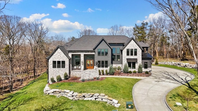 6128 Lookaway Cir, Franklin, TN 37067 - view of front facade with stone siding, a front yard, and curved driveway