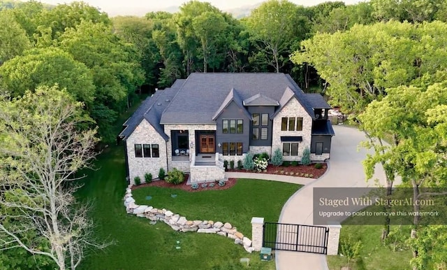 6128 Lookaway Cir, Franklin, TN 37067 - view of front of home with stone siding, a gate, curved driveway, and a front yard