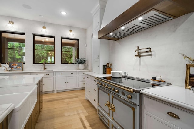 6128 Lookaway Cir, Franklin, TN 37067 - kitchen with electric stove, custom range hood, light wood-style flooring, light countertops, and white cabinets