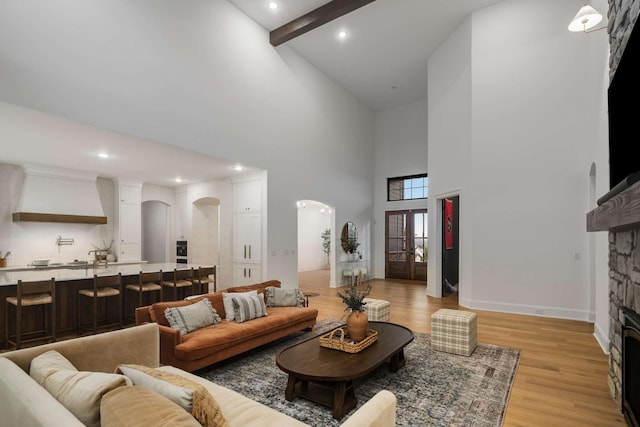 6128 Lookaway Cir, Franklin, TN 37067 - living area with arched walkways, a fireplace, a high ceiling, light wood finished floors, and recessed lighting