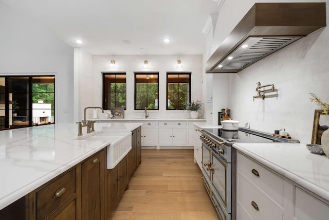 6128 Lookaway Cir, Franklin, TN 37067 - kitchen featuring premium range hood, stainless steel range, white cabinetry, recessed lighting, and light wood-style floors