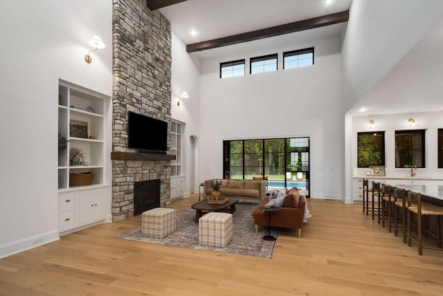 6128 Lookaway Cir, Franklin, TN 37067 - living room with a fireplace, wood finished floors, beamed ceiling, a high ceiling, and built in shelves