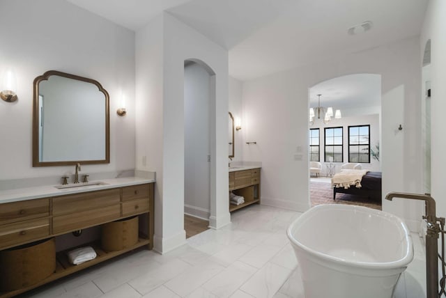 6128 Lookaway Cir, Franklin, TN 37067 - ensuite bathroom with two vanities, a freestanding bath, marble finish floors, and a chandelier