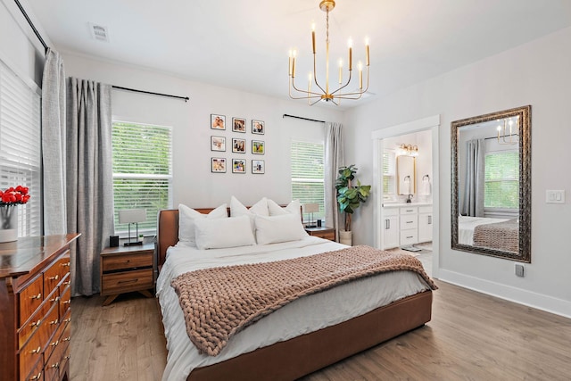 1003 Autumn Ridge Ct, Spring Hill, TN 37174 - bedroom with a chandelier, wood finished floors, multiple windows, and ensuite bath