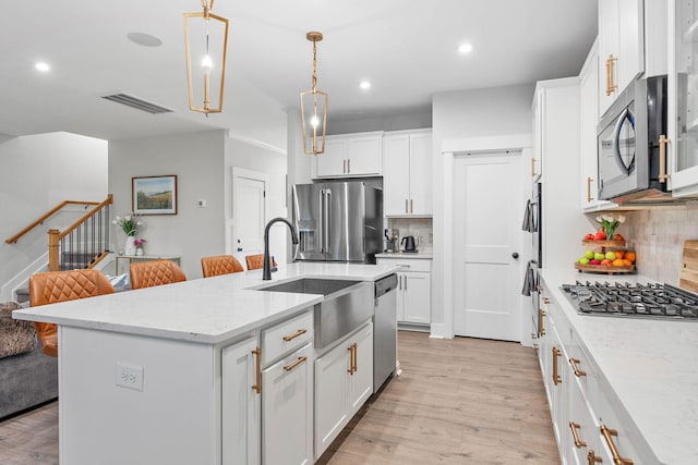 1003 Autumn Ridge Ct, Spring Hill, TN 37174 - kitchen featuring appliances with stainless steel finishes, decorative backsplash, light wood-type flooring, white cabinets, and recessed lighting