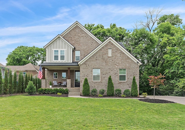 1003 Autumn Ridge Ct, Spring Hill, TN 37174 - craftsman-style home with covered porch, board and batten siding, a front lawn, and brick siding