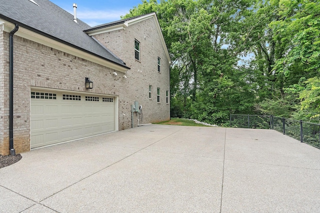 1003 Autumn Ridge Ct, Spring Hill, TN 37174 - view of side of property featuring concrete driveway, brick siding, roof with shingles, and an attached garage