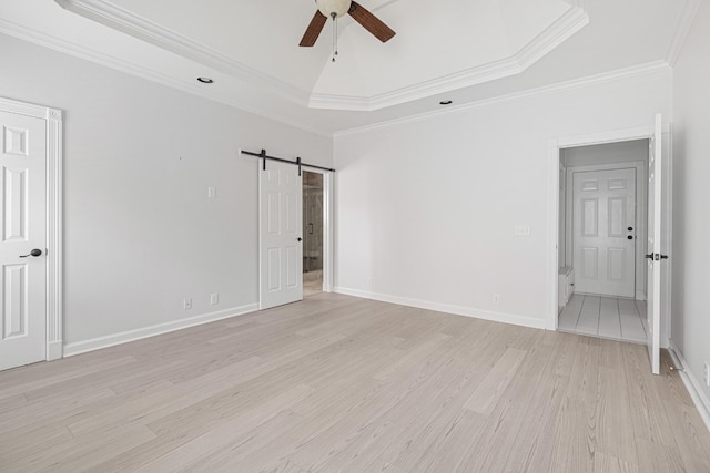 324 Julianna Cir, Franklin, TN 37064 - unfurnished bedroom with a raised ceiling, a barn door, light wood-type flooring, ornamental molding, and a ceiling fan