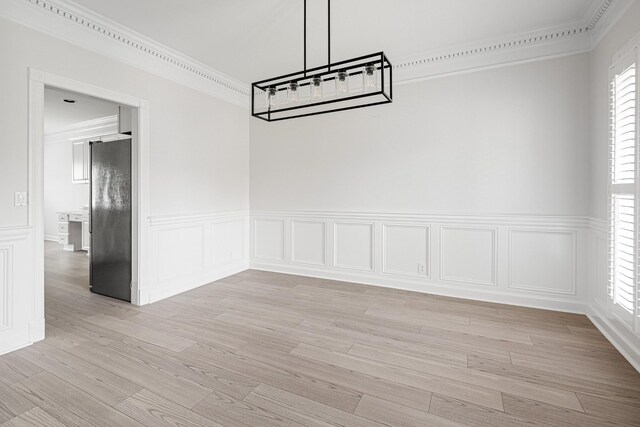 324 Julianna Cir, Franklin, TN 37064 - unfurnished dining area featuring crown molding, a decorative wall, wainscoting, and light wood-style floors