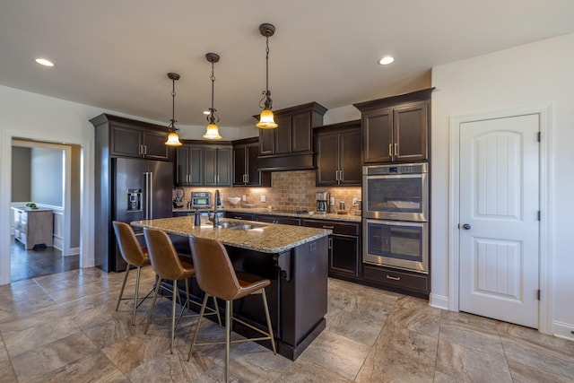 160 Dobson Knob Trl, Nolensville, TN 37135 - kitchen featuring appliances with stainless steel finishes, dark brown cabinets, light stone countertops, a kitchen breakfast bar, and backsplash