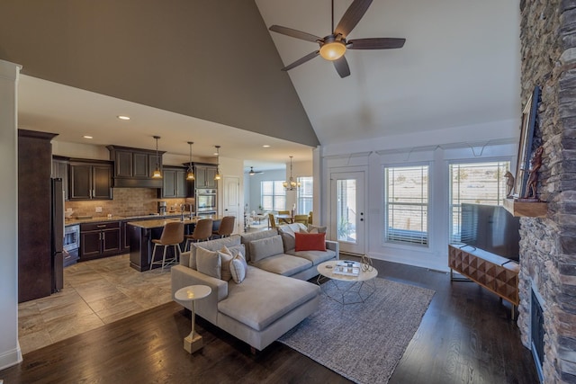 160 Dobson Knob Trl, Nolensville, TN 37135 - living area featuring high vaulted ceiling, a ceiling fan, a fireplace, wood finished floors, and a chandelier