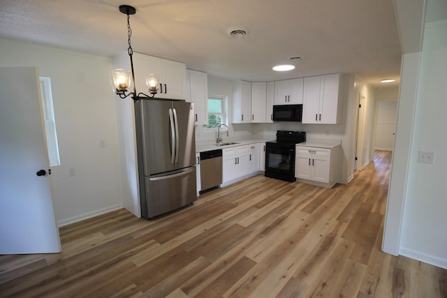 151 Dawn St, Morrison, TN 37357 - kitchen with black appliances, white cabinets, light countertops, light wood-type flooring, and pendant lighting