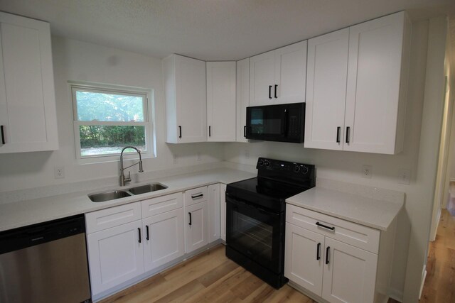 151 Dawn St, Morrison, TN 37357 - kitchen with black appliances, light wood-style flooring, and white cabinetry