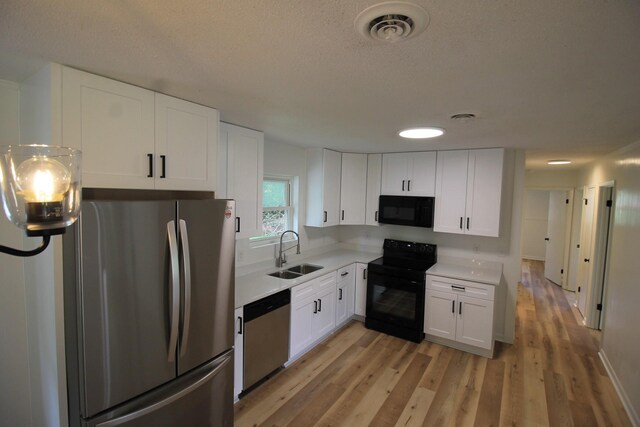 151 Dawn St, Morrison, TN 37357 - kitchen featuring black appliances, light countertops, light wood-type flooring, white cabinets, and a textured ceiling