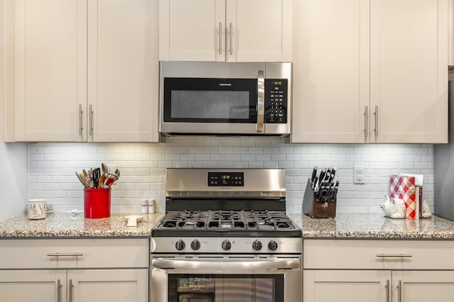 414 Manor Row, Pleasant View, TN 37146 - kitchen featuring appliances with stainless steel finishes, backsplash, and light stone countertops