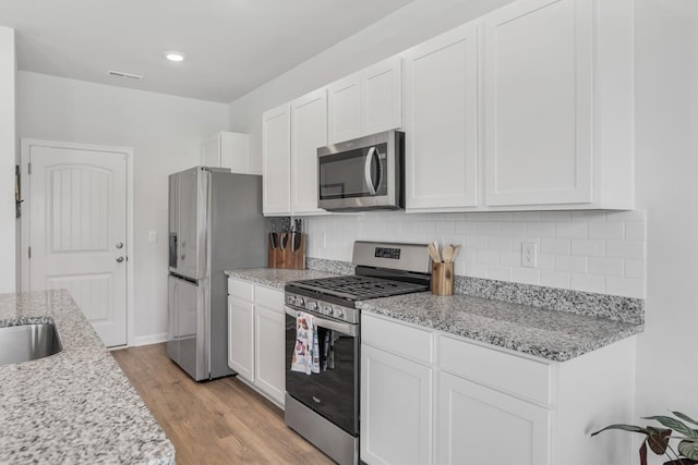 2400 Kaycee Ct, Lebanon, TN 37087 - kitchen with appliances with stainless steel finishes, white cabinets, light wood finished floors, backsplash, and recessed lighting