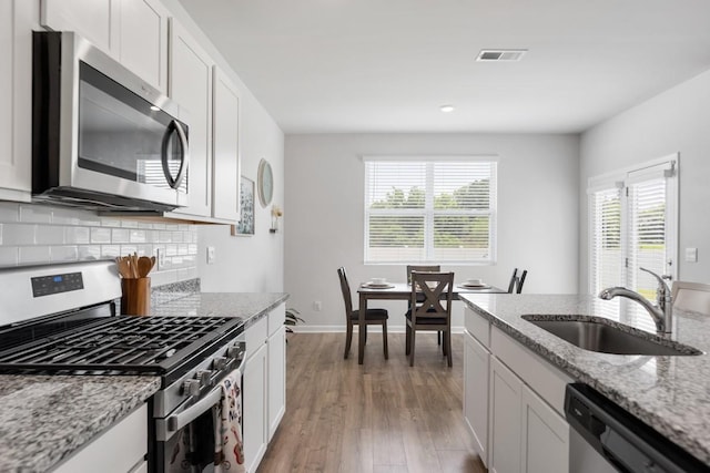 2400 Kaycee Ct, Lebanon, TN 37087 - kitchen featuring stainless steel appliances, healthy amount of natural light, light wood-style flooring, white cabinetry, and recessed lighting