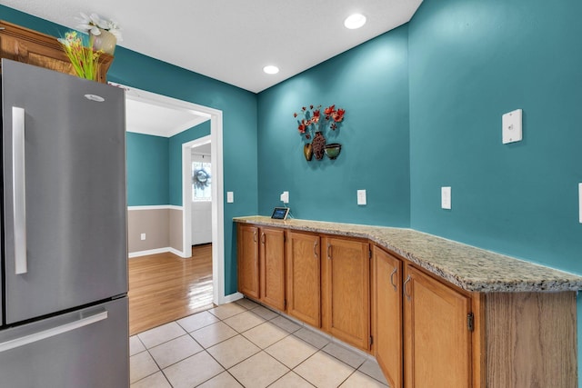 1128 Tiftonia View Rd, Chattanooga, TN 37419 - kitchen with freestanding refrigerator, light tile patterned flooring, brown cabinets, and recessed lighting