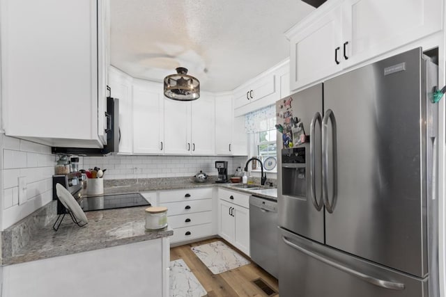 70 Nancy Ave, Cadiz, KY 42211 - kitchen featuring appliances with stainless steel finishes, white cabinetry, backsplash, and wood finished floors