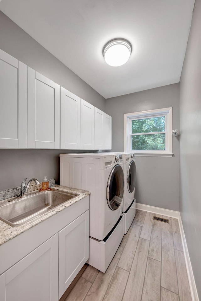 206 Stillcreek Dr, Franklin, TN 37064 - washroom with washing machine and dryer, cabinet space, and light wood finished floors