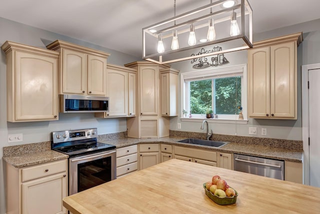 206 Stillcreek Dr, Franklin, TN 37064 - kitchen with appliances with stainless steel finishes, wooden counters, cream cabinets, and pendant lighting