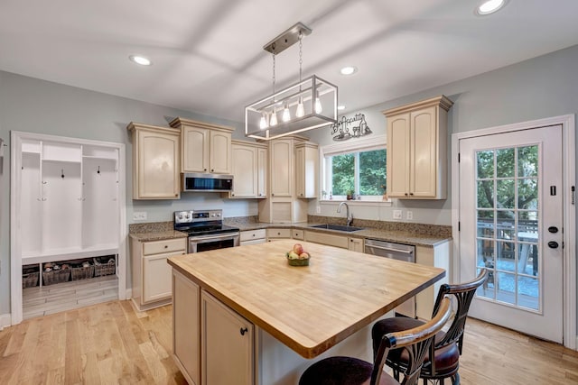 206 Stillcreek Dr, Franklin, TN 37064 - kitchen with stainless steel appliances, butcher block countertops, hanging light fixtures, light wood finished floors, and a breakfast bar