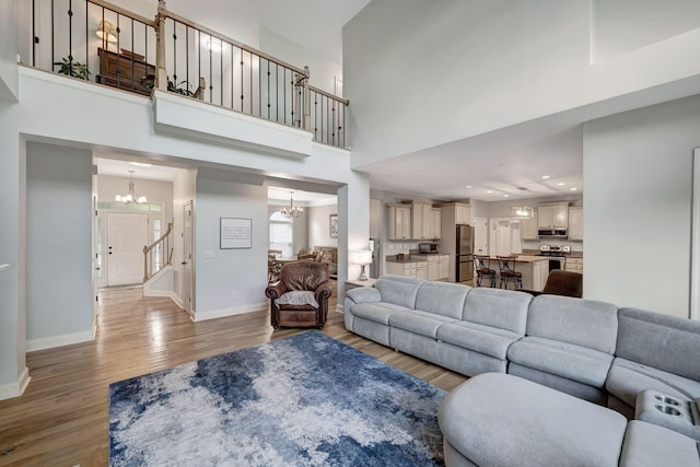 206 Stillcreek Dr, Franklin, TN 37064 - living room with a chandelier, light wood-type flooring, a high ceiling, and recessed lighting