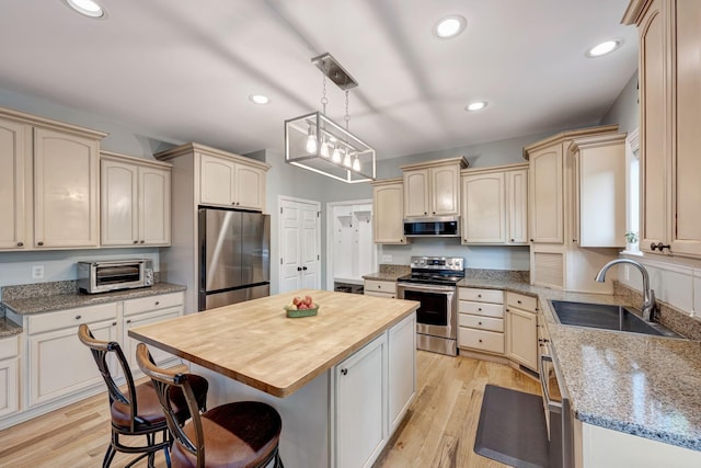 206 Stillcreek Dr, Franklin, TN 37064 - kitchen featuring appliances with stainless steel finishes, butcher block counters, a kitchen island, light wood-type flooring, and recessed lighting