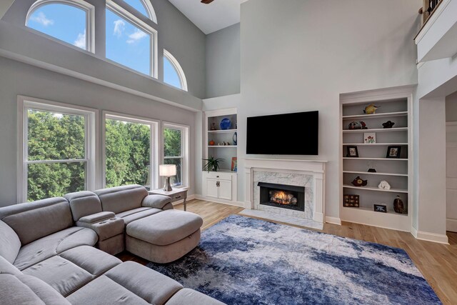 206 Stillcreek Dr, Franklin, TN 37064 - living room with a towering ceiling, a premium fireplace, wood finished floors, and built in features