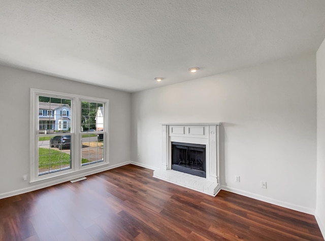 480 Bamburg Dr, Clarksville, TN 37040 - unfurnished living room with wood finished floors, a brick fireplace, and a textured ceiling
