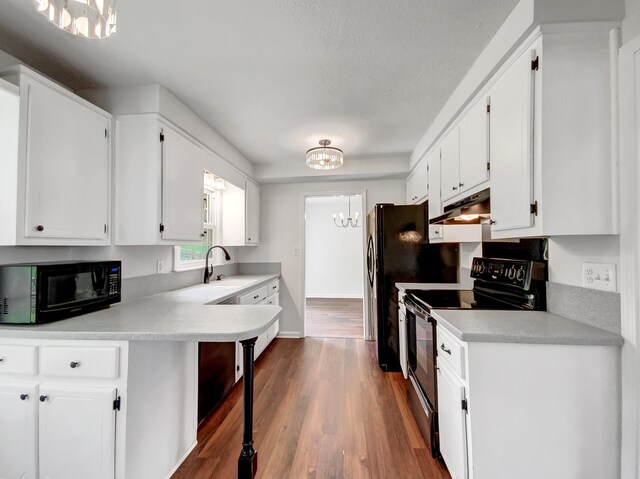 480 Bamburg Dr, Clarksville, TN 37040 - kitchen featuring black appliances, a chandelier, under cabinet range hood, white cabinetry, and light countertops