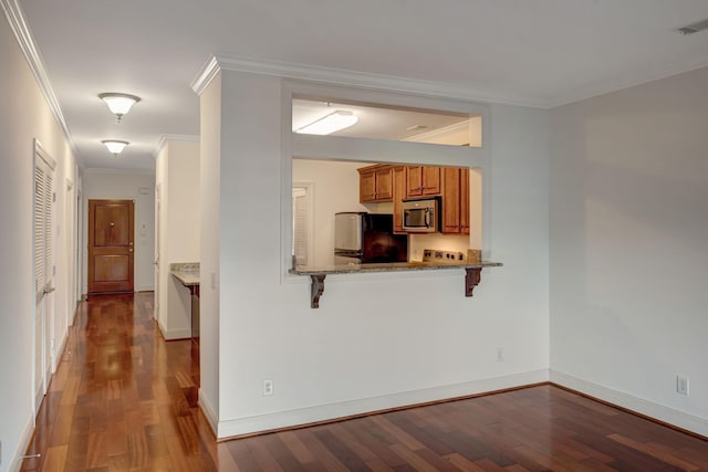 301 Criddle St Unit 304, Nashville, TN 37219 - kitchen with stainless steel microwave, freestanding refrigerator, wood finished floors, crown molding, and brown cabinets
