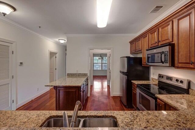 301 Criddle St Unit 304, Nashville, TN 37219 - kitchen with stainless steel appliances, dark wood-type flooring, light stone countertops, crown molding, and brown cabinetry