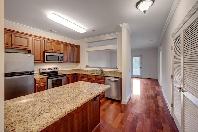 301 Criddle St Unit 304, Nashville, TN 37219 - kitchen featuring stainless steel appliances, ornamental molding, dark wood-style flooring, light stone countertops, and brown cabinets