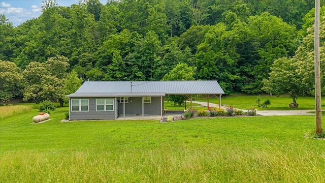 49 Je Sartain Rd, Manchester, TN 37355 - view of front of property featuring a front lawn, a metal roof, a carport, a forest view, and driveway