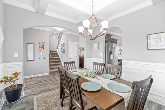 1148 Folly Beach Dr, Clarksville, TN 37042 - dining space with arched walkways, a chandelier, wood finished floors, crown molding, and a wainscoted wall